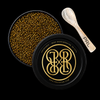 Open round black tin of caviar with visible golden-brown roe, a branded black lid with a gold monogram, and a small spoon on a black background. The spoon shows the brand name PRL.