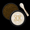 Open round black tin of PRL Caviar brand sturgeon caviar on a black background, showing dark brown caviar pearls, a cream-and-gold branded lid, and a small wooden spoon with PRL branding.